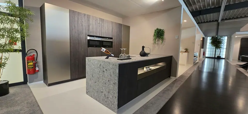 Kookeiland met terrazzo-look werkblad en donkere hoge kasten